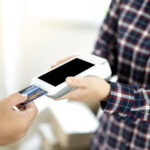 Close-up of entrepreneur using card machine for a card payment