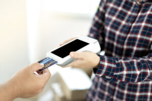 Close-up of entrepreneur using card machine for a card payment