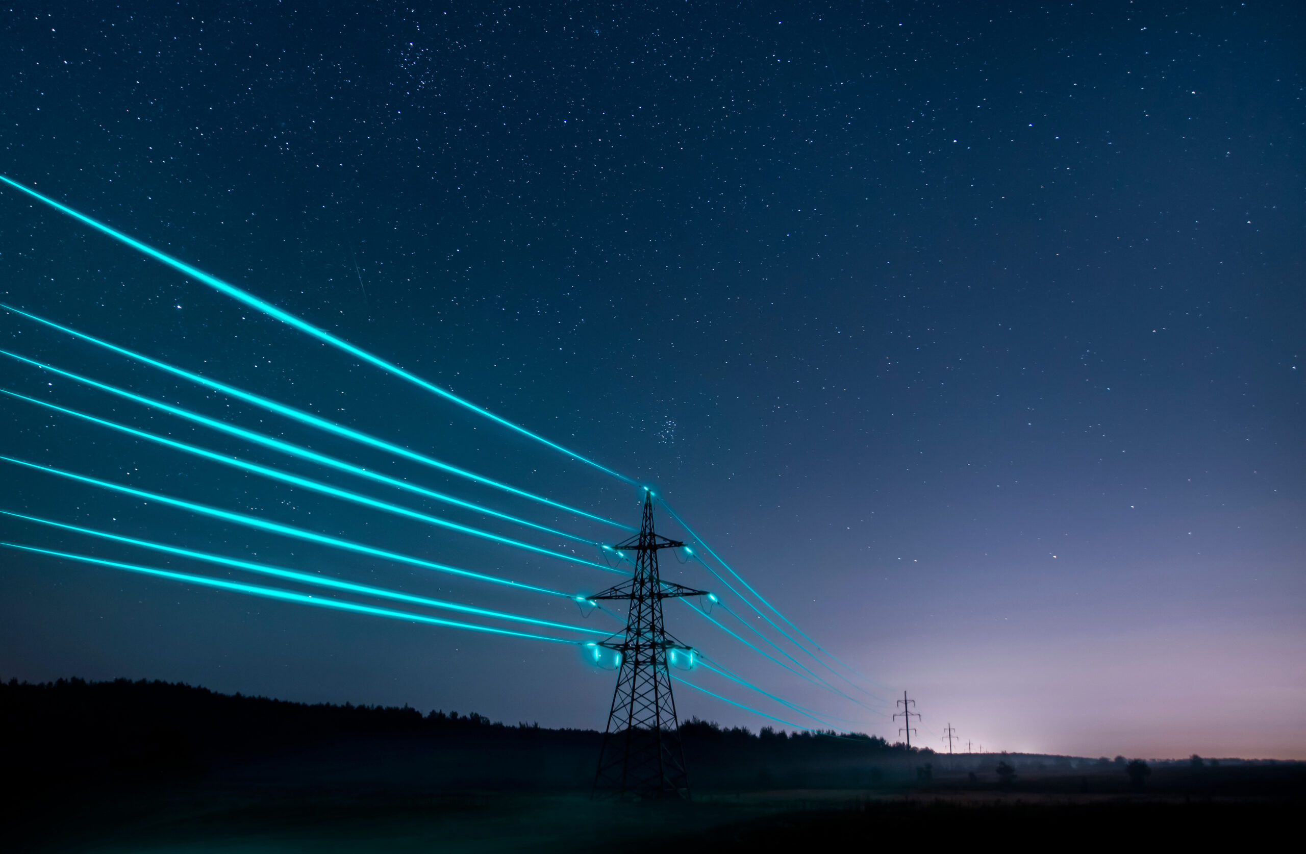 Electricity transmission towers with glowing wires against the starry sky representing market wide half hourly meter settlements