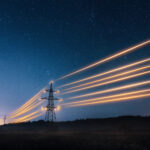 electricity towers with orange glowing wires representing market wide half hourly meter settlements