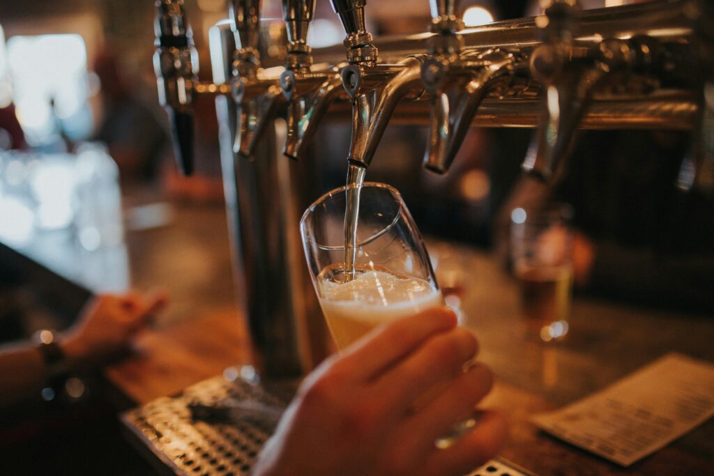 hand pulling a pint using tap to represent alcohol supply