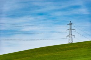 pylon on a field with blue sky representing energy contracts